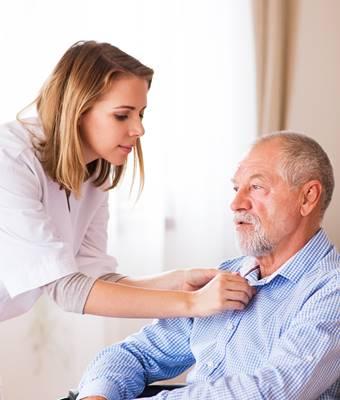 Therapist getting vitals from elderly man in wheelchair