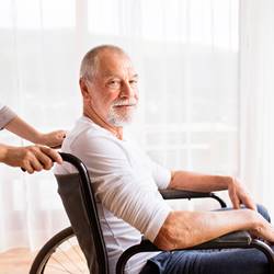 Elderly man in wheelchair profile and looking at camera