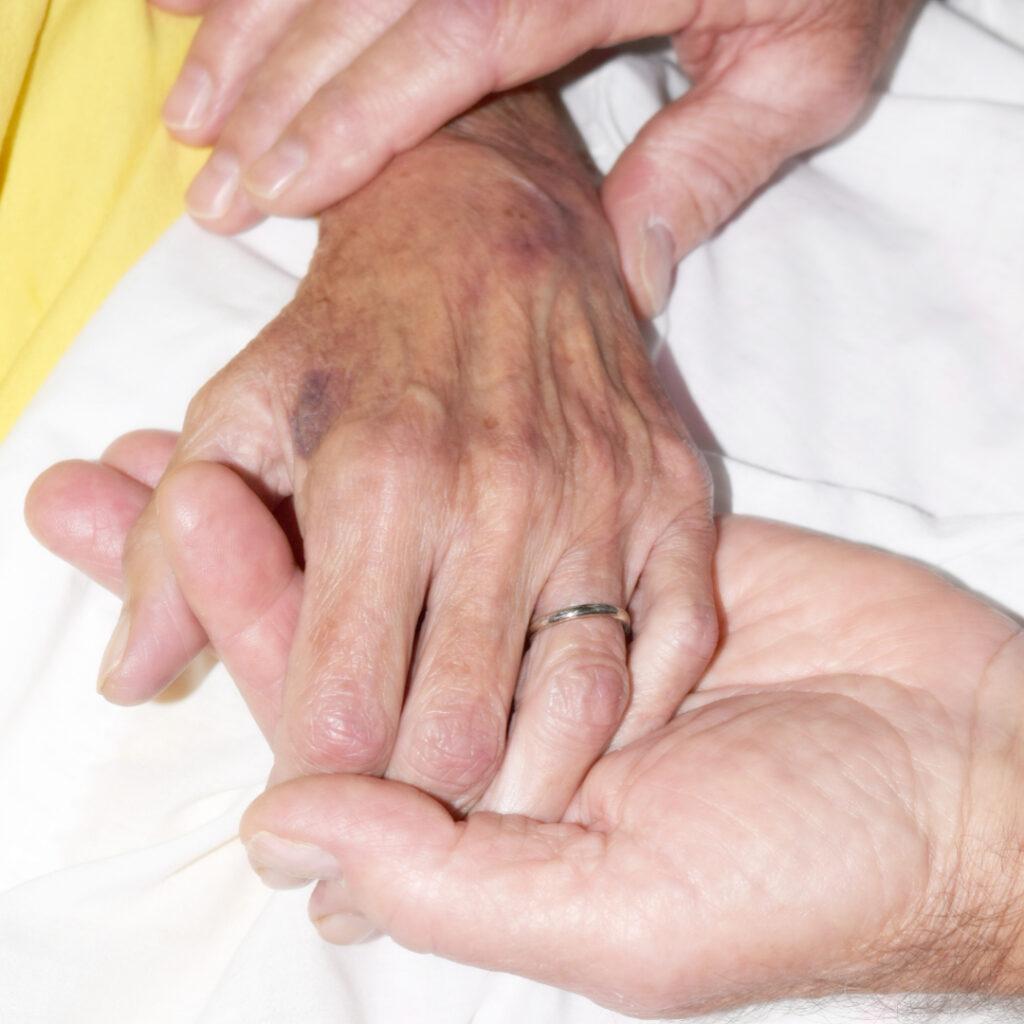 Hand of elderly woman being held